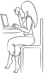 Woman sitting at a desk at her computer facing left